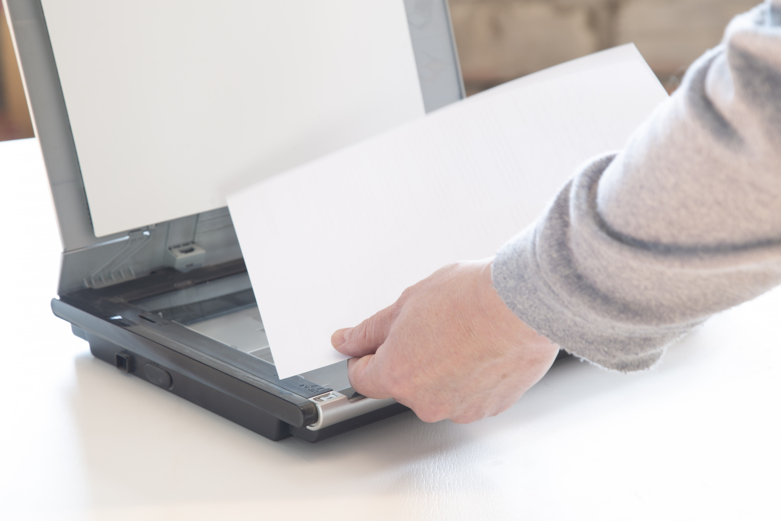 Das Einlegen eines Ausdrucks in den Scanner.